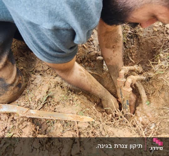 אדם חופר באדמה לתיקון צינור מים